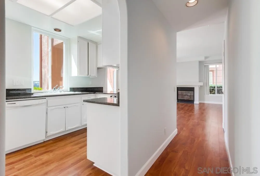 3525 Cameo Drive, Unit 92 Oceanside, CA 92056 - Photo 14 of 43 a kitchen with wooden floors and white appliances