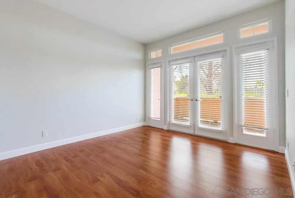 3525 Cameo Drive, Unit 92 Oceanside, CA 92056 - Photo 23 of 43 a view of an empty room with wooden floor and a window