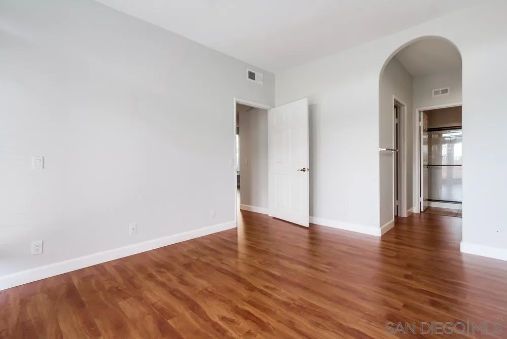 3525 Cameo Drive, Unit 92 Oceanside, CA 92056 - Photo 24 of 43 a view of an empty room with wooden floor and a window