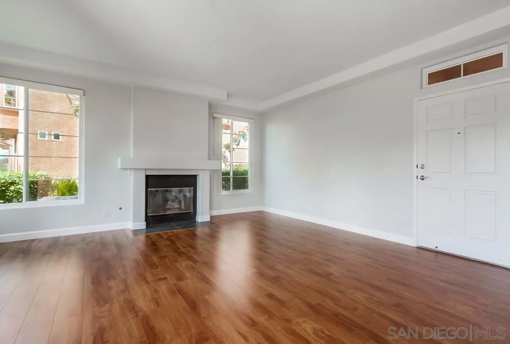3525 Cameo Drive, Unit 92 Oceanside, CA 92056 - Photo 7 of 43 an empty room with wooden floor fireplace and windows