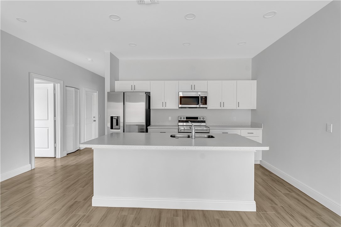 3395 3rd Place Vero Beach, FL 32968 - Photo 11 of 15 a large white kitchen with kitchen island sink and refrigerator