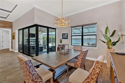 a view of a dining room with furniture a chandelier and wooden floor