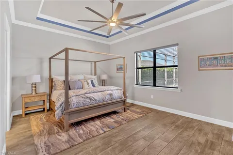 a bedroom with a bed and a flat tv screen on dresser