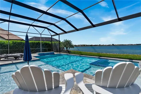 a view of a swimming pool with lawn chairs under an umbrella