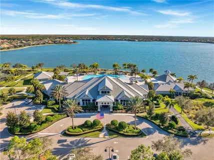 a dining room with wooden floor a chandelier a glass table and chairs