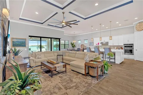 a kitchen with stainless steel appliances kitchen island granite countertop a table chairs sink and cabinets