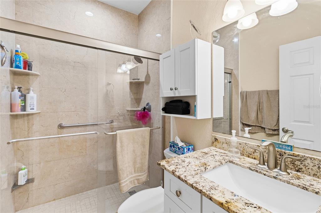 150 164th Avenue Redington Beach, FL 33708 - Photo 42 of 64 a bathroom with a granite countertop sink a mirror and a shower