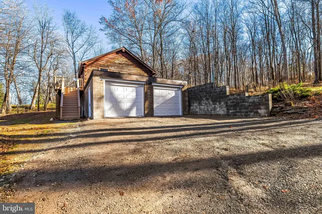 a view of a house with a yard and large trees