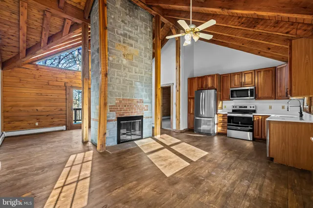 a open kitchen with granite countertop a stove top oven a sink and a microwave