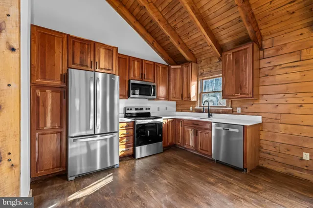 a kitchen with stainless steel appliances granite countertop a refrigerator a stove a sink dishwasher and a refrigerator