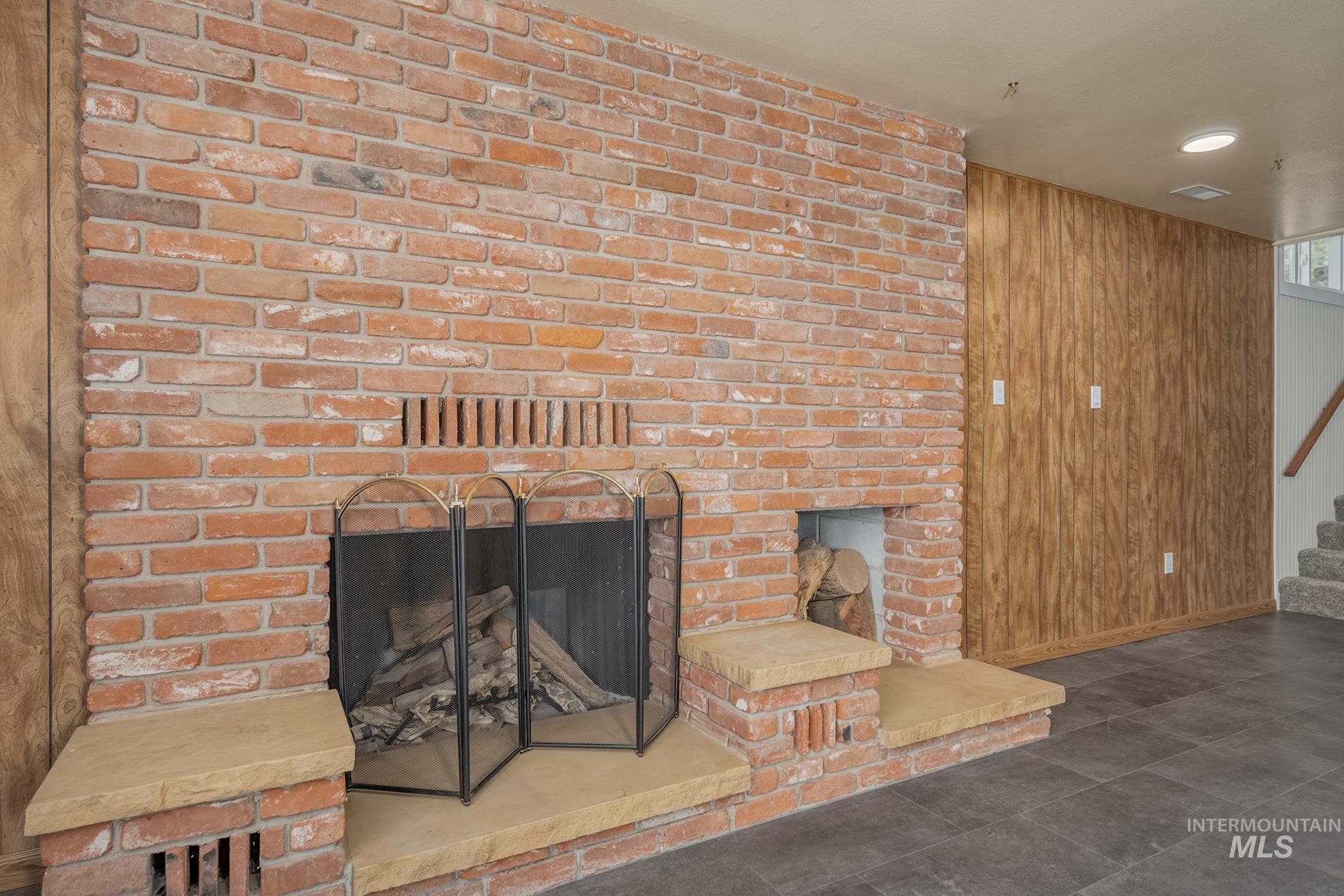 748 Pringle Road Weiser, ID 83672 - Photo 23 of 47 Brick fireplace with a stone hearth and integrated wood storage niche