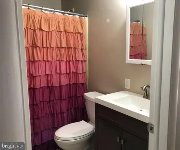 a bathroom with a sink a toilet and shower curtain