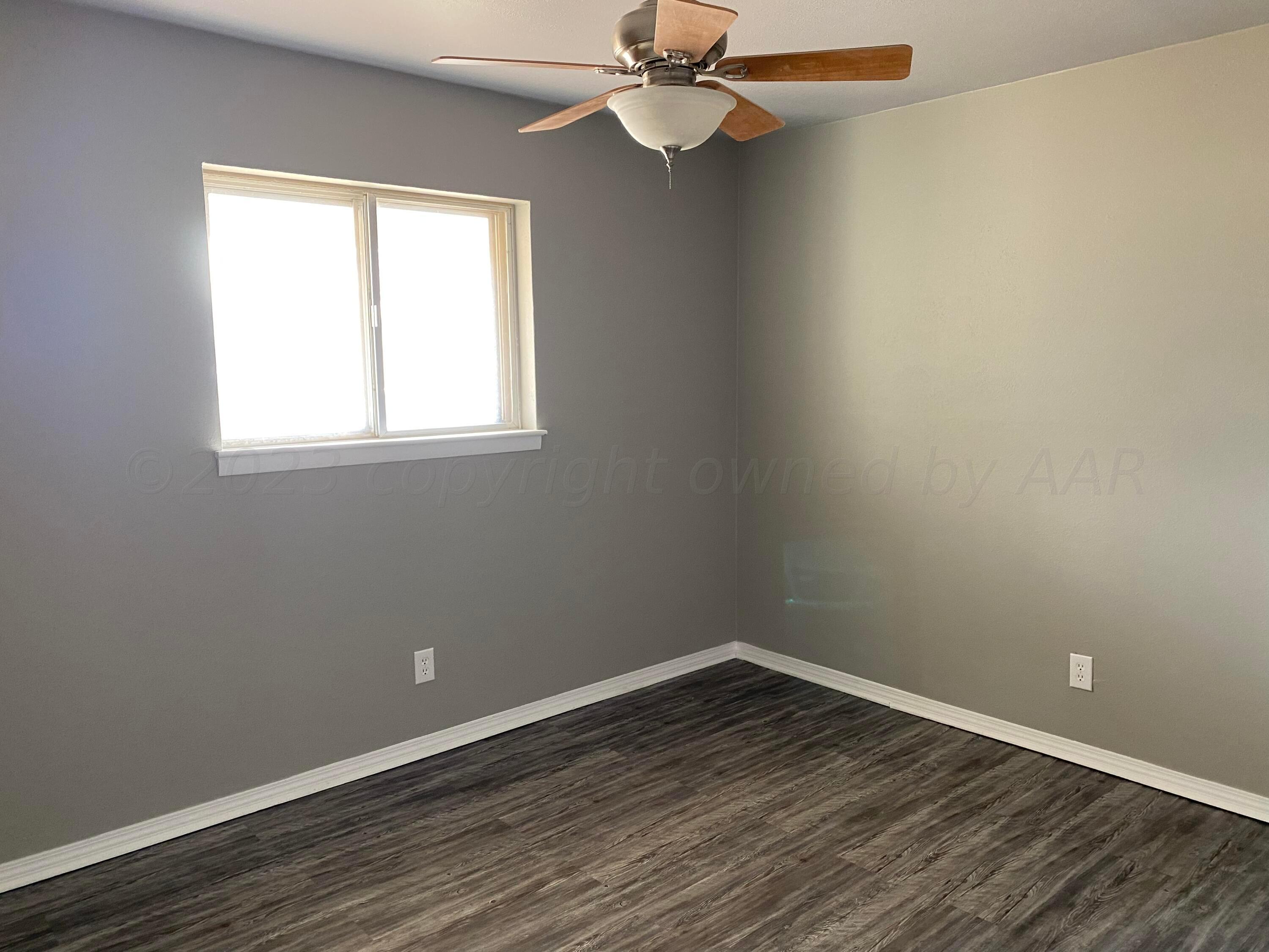 4700 Oregon Trail Amarillo, TX 79109 - Photo 5 of 9 an empty room with wooden floor fan and windows