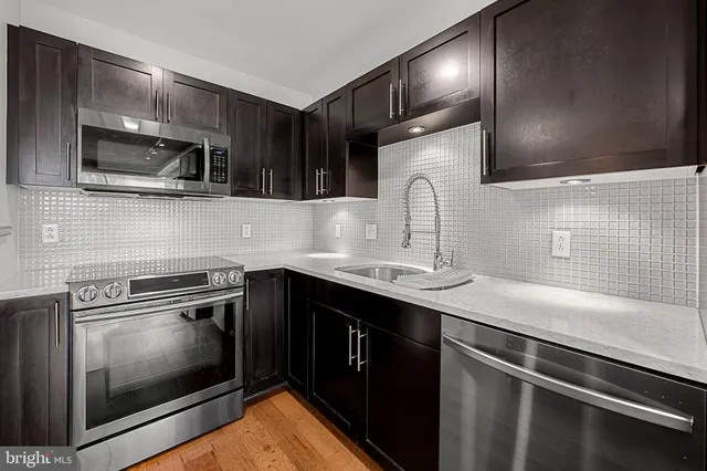 a kitchen with stainless steel appliances a sink stove and microwave