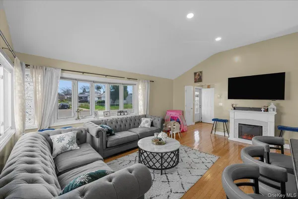 a living room with furniture a flat screen tv and a large window