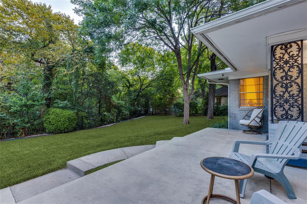 737 North Hampton Road Dallas, TX 75208 - Photo 5 of 30 Outdoor living beneath mature trees, with the creek and surrounding greenery close at hand.