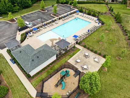 an aerial view of a residential houses with outdoor space and a swimming pool
