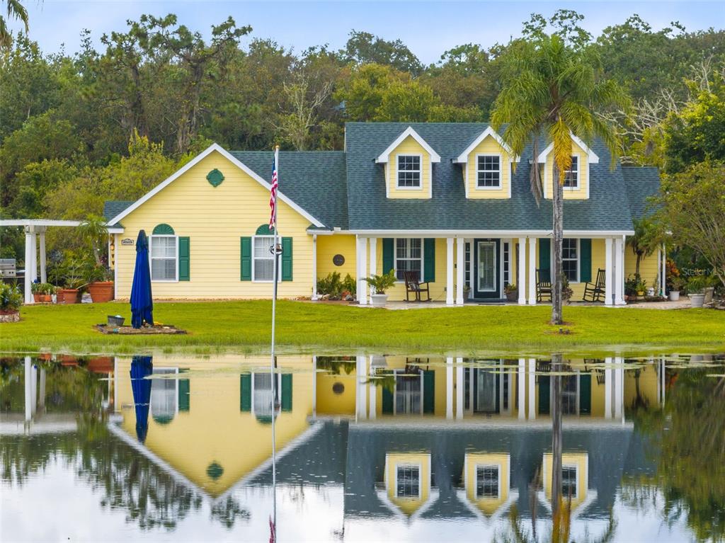 a view of a white house with a swimming pool and porch