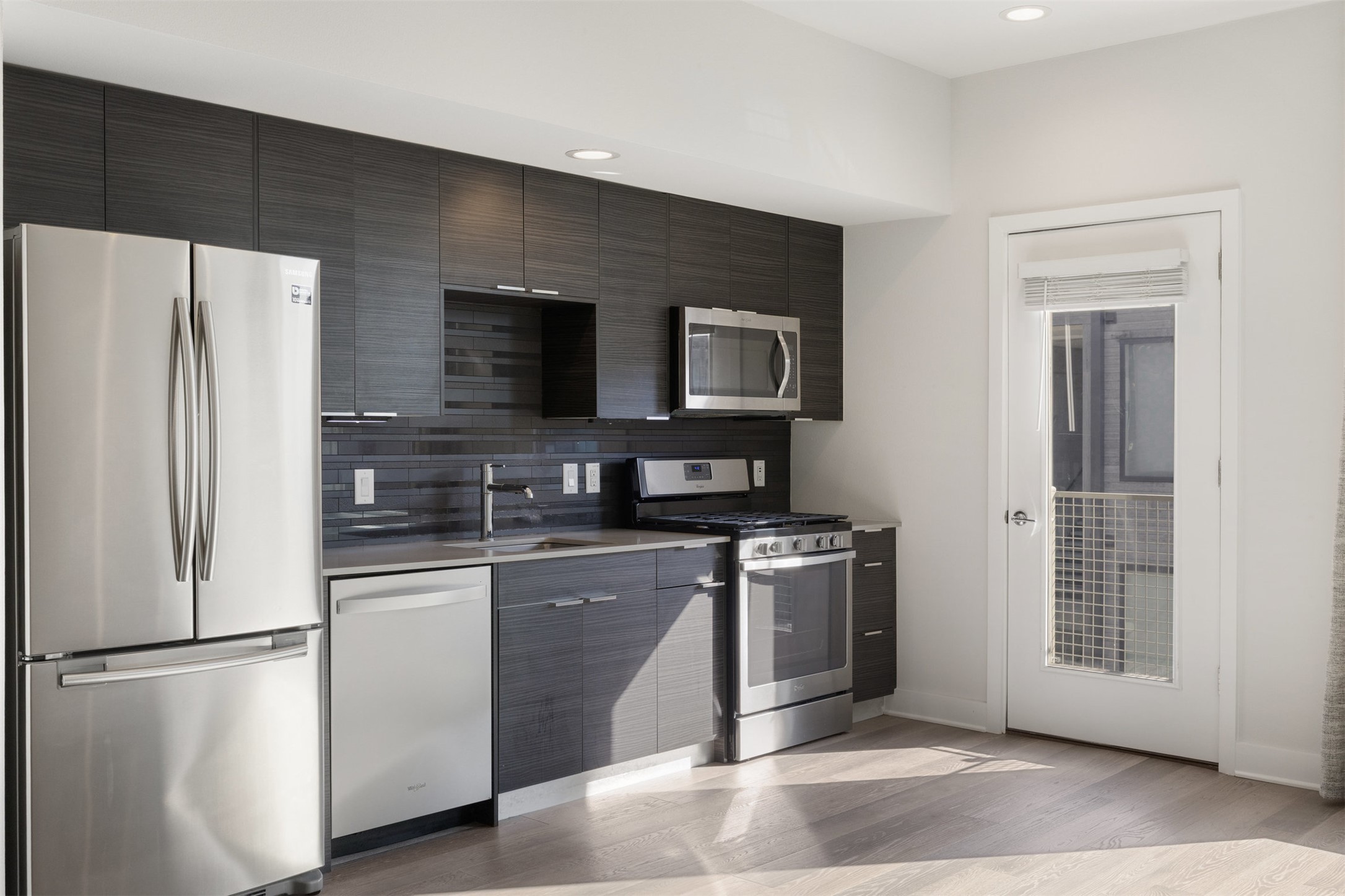 1800 East 4th Street, Unit 327 Austin, TX 78702 - Photo 16 of 20 a kitchen with stainless steel appliances granite countertop a refrigerator a stove a sink and a microwave