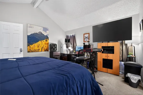 a bedroom with a bed a flat screen tv and dresser