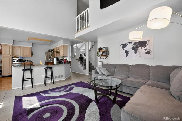 a living room with furniture and a view of kitchen