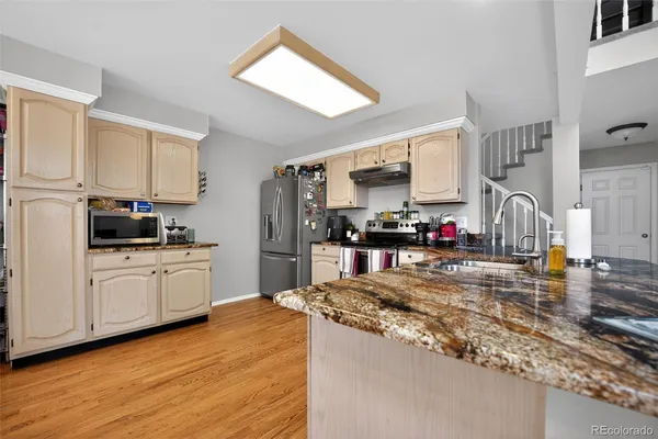 a kitchen with granite countertop a stove a sink dishwasher and a refrigerator