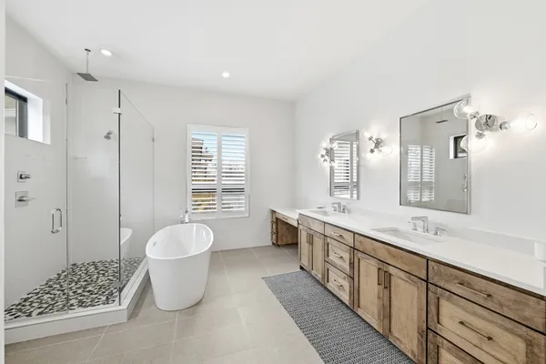 a spacious bathroom with a double vanity sink a toilet and a shower