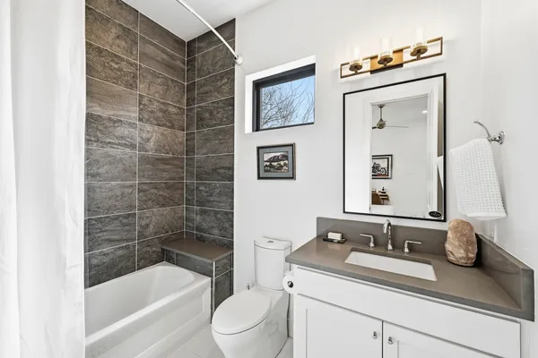 a bathroom with a granite countertop sink toilet and shower