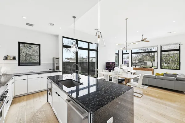 a kitchen with stainless steel appliances granite countertop a sink and a wooden floor