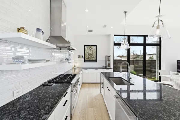 a kitchen with stainless steel appliances granite countertop a sink and wooden cabinets