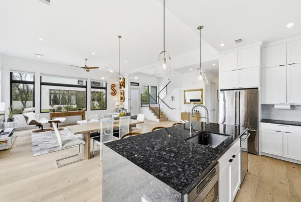 a kitchen with stainless steel appliances granite countertop a sink a counter and chairs