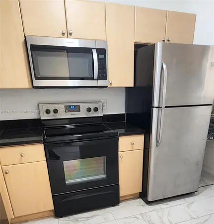 a kitchen with stainless steel appliances a refrigerator a stove a microwave and cabinets