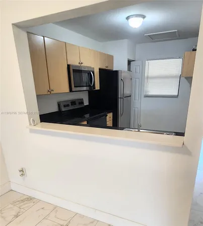 a kitchen with stainless steel appliances a refrigerator and microwave
