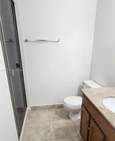 a bathroom with a granite countertop sink toilet and a mirror
