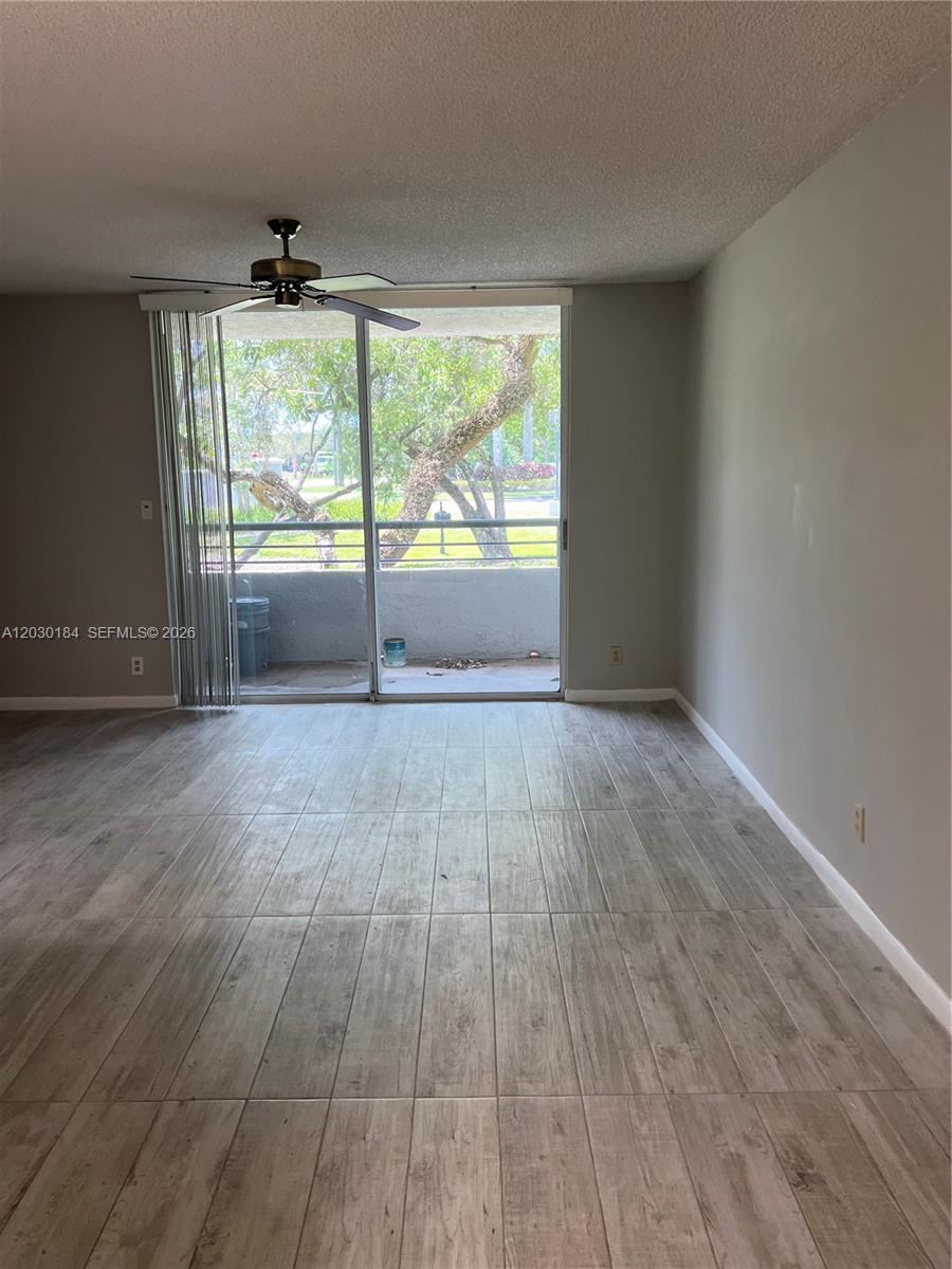 951 Lyons Road, Unit 6104 Coconut Creek, FL 33063 - Photo 3 of 18 a view of an empty room with wooden floor and a window