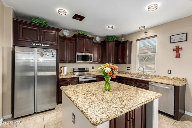 a kitchen with stainless steel appliances granite countertop a sink refrigerator and microwave