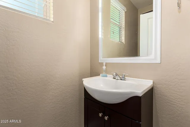 a bathroom with a sink a mirror and a window