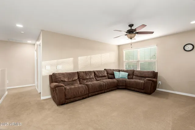 a living room with furniture and a ceiling fan