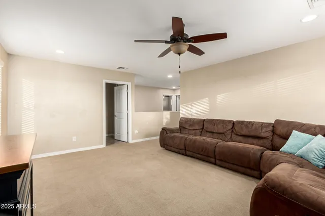 a living room with furniture and a ceiling fan