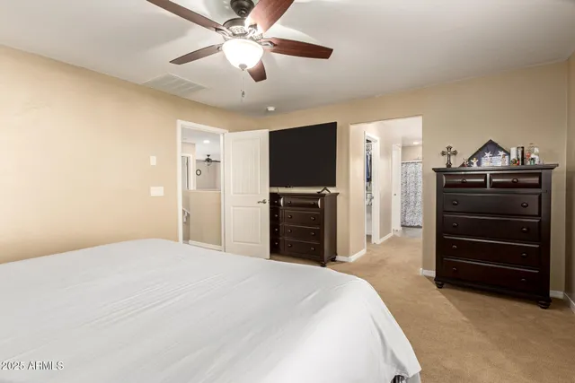 a bedroom with a bed and a flat tv screen on dresser