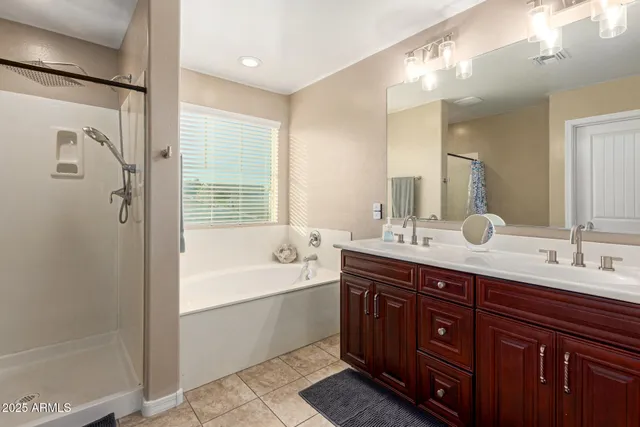 a spacious bathroom with a tub sink shower and mirror