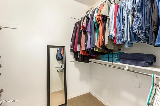 a view of walk in closet with clothes