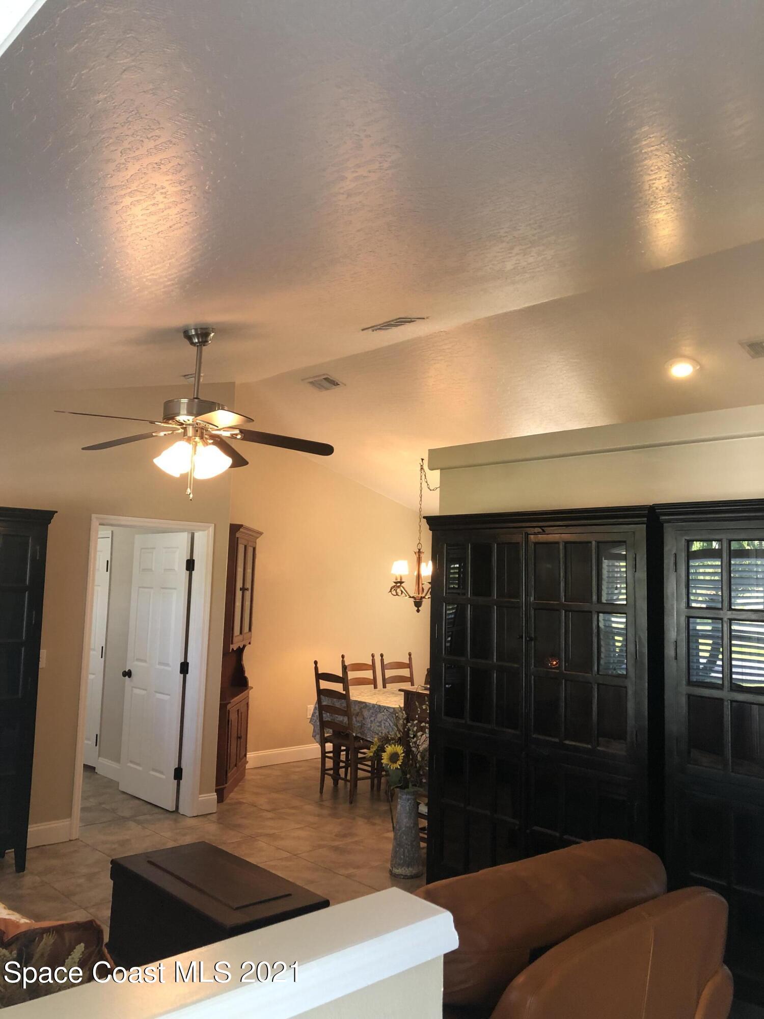 2865 Digby Road Southeast Palm Bay, FL 32909 - Photo 3 of 42 a living room with furniture a chandelier and a dining table