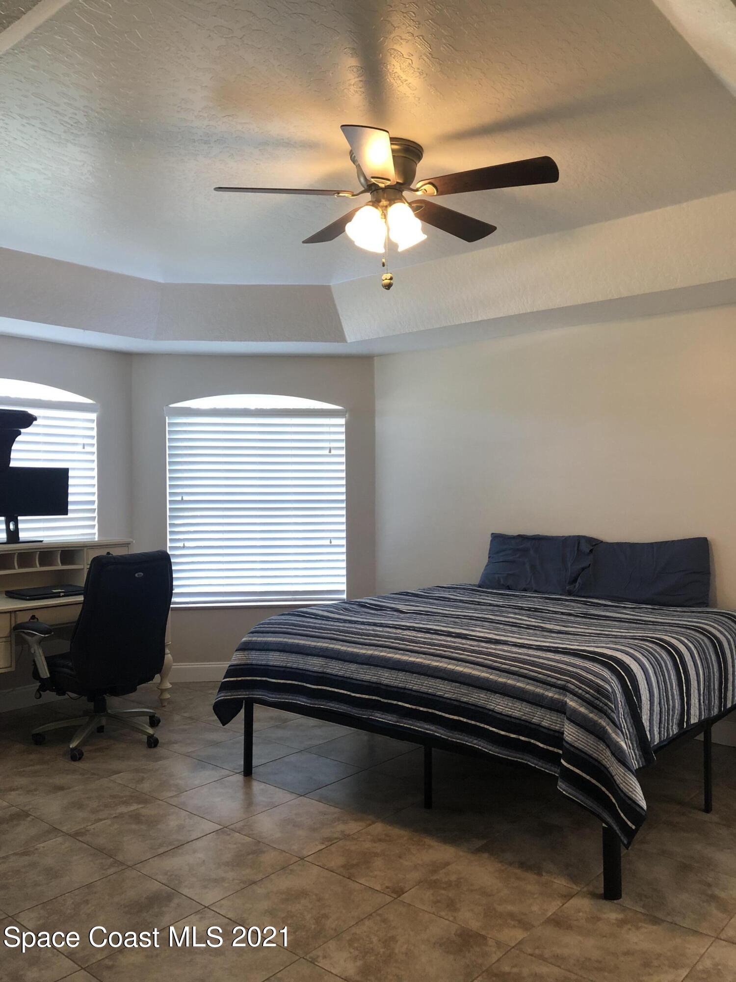 2865 Digby Road Southeast Palm Bay, FL 32909 - Photo 22 of 42 a bedroom with a bed and a chandelier