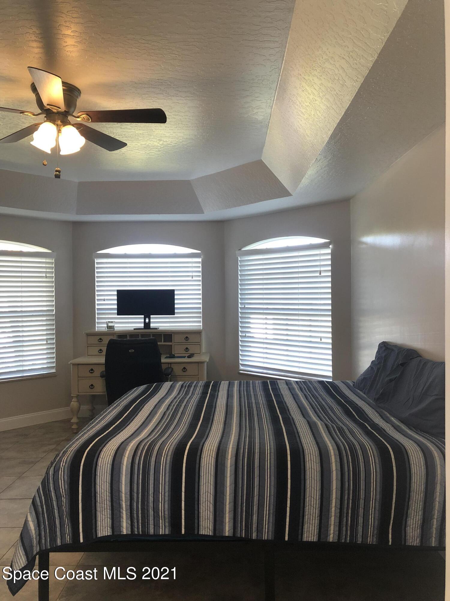 2865 Digby Road Southeast Palm Bay, FL 32909 - Photo 23 of 42 a bedroom with a bed and a chandelier