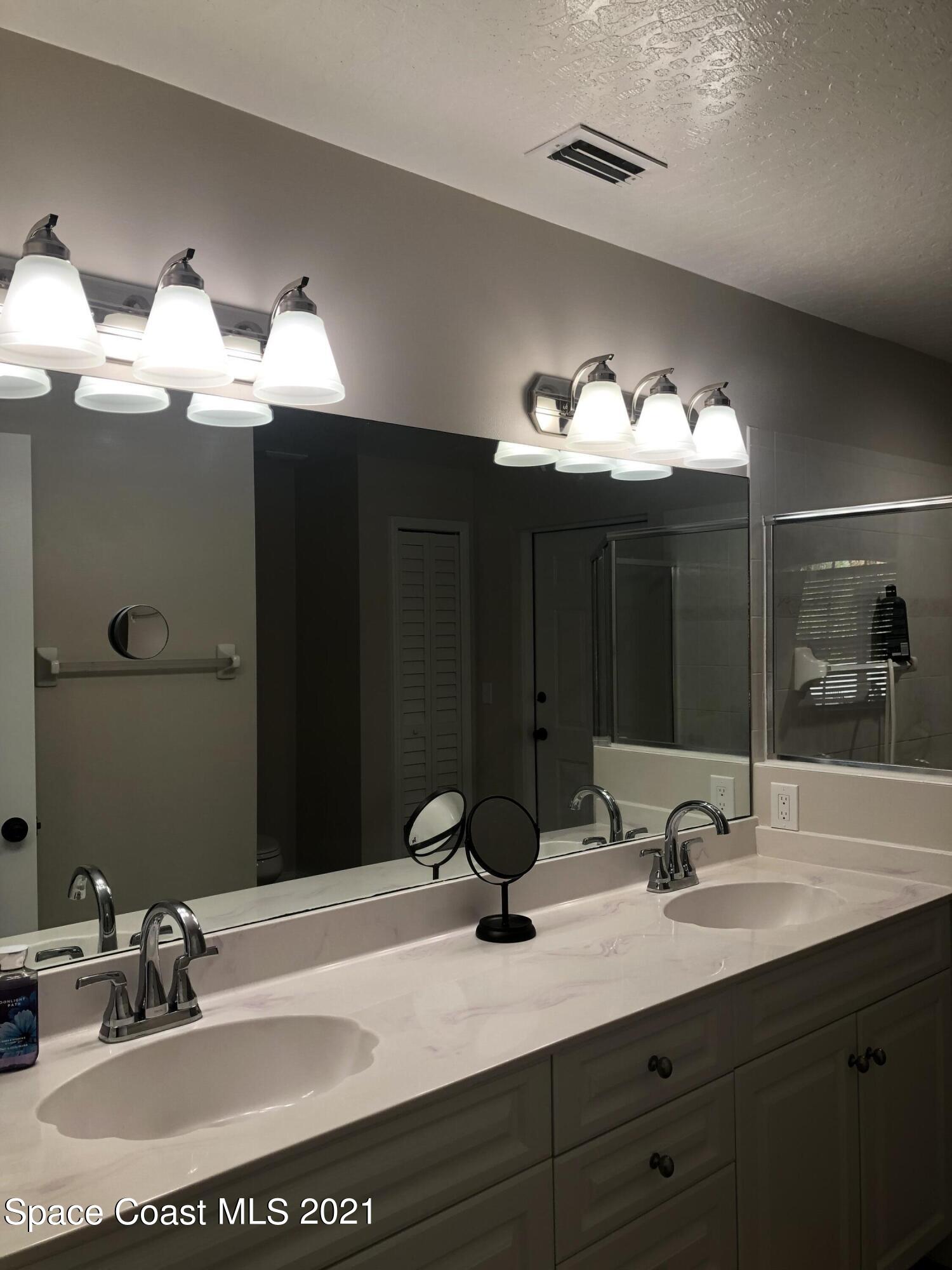 2865 Digby Road Southeast Palm Bay, FL 32909 - Photo 26 of 42 a bathroom with a sink and a mirror