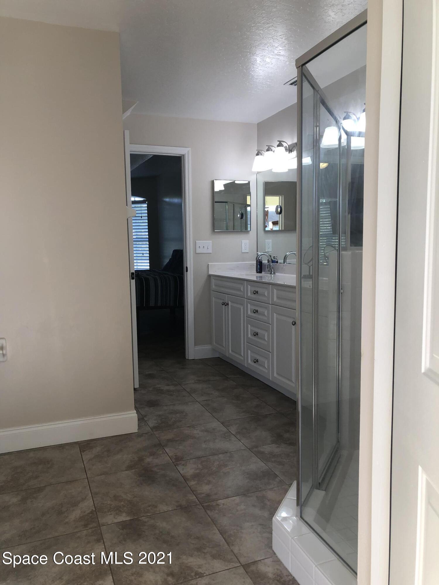 2865 Digby Road Southeast Palm Bay, FL 32909 - Photo 28 of 42 a bathroom with a glass shower door and a sink