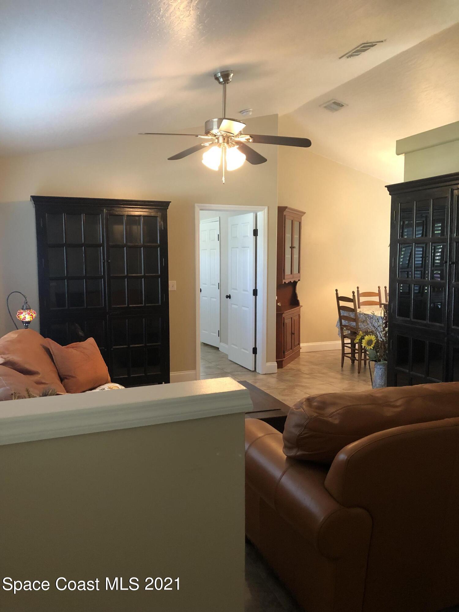 2865 Digby Road Southeast Palm Bay, FL 32909 - Photo 4 of 42 a living room with furniture and a chandelier
