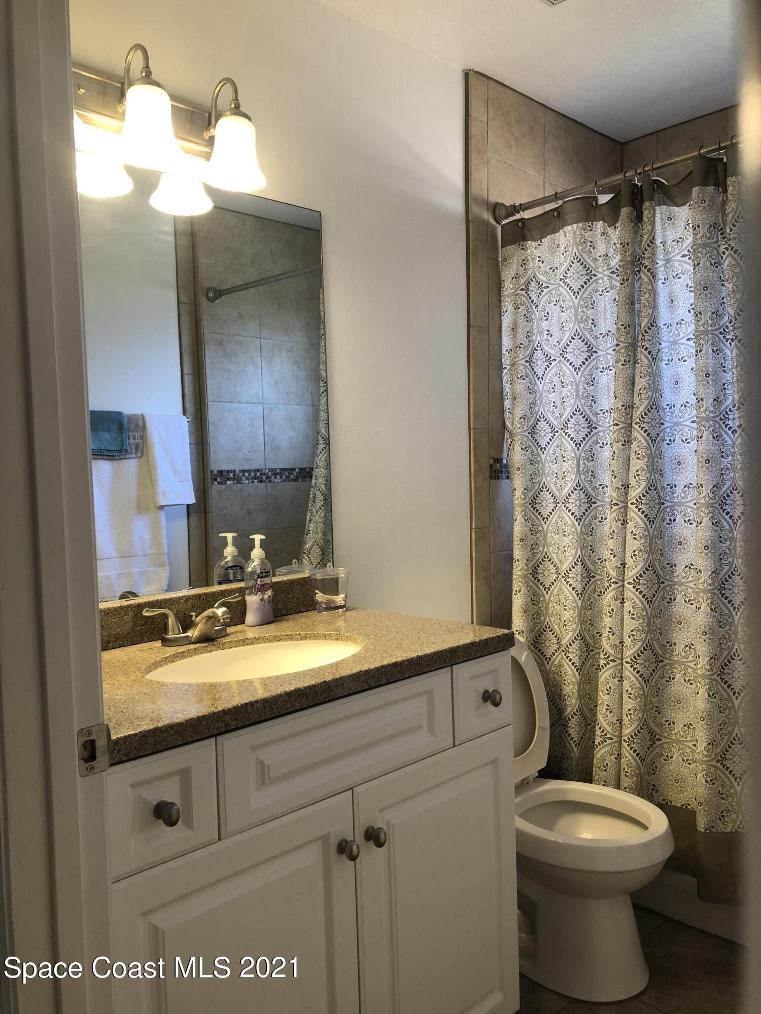 2865 Digby Road Southeast Palm Bay, FL 32909 - Photo 36 of 42 a bathroom with a granite countertop sink mirror vanity and toilet