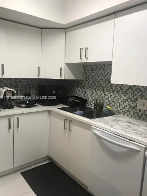 a kitchen with a stove and white cabinets